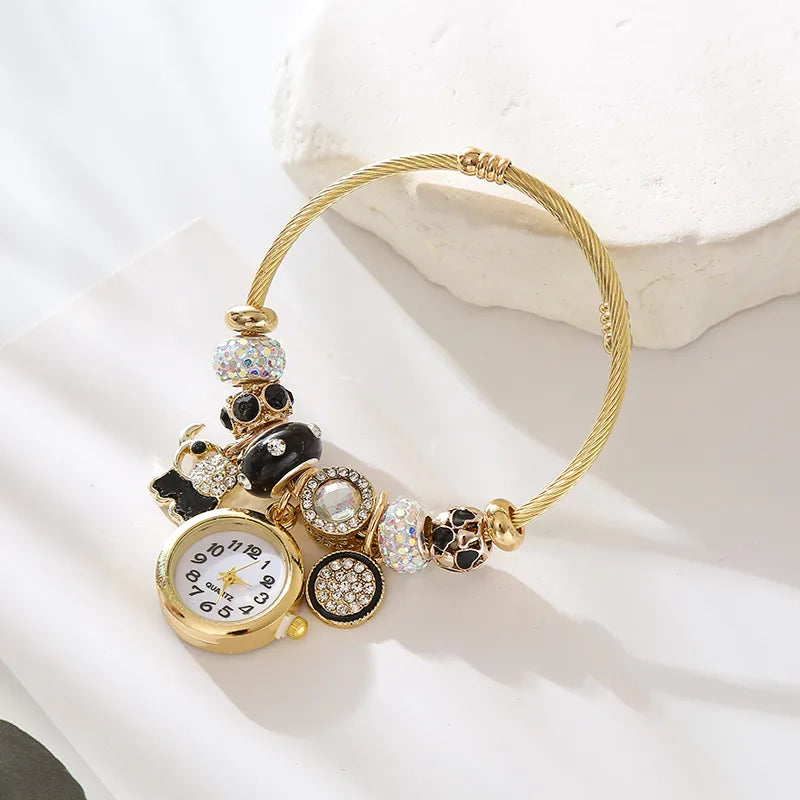 Reloj dorado de brazalete con colgantes de corazón