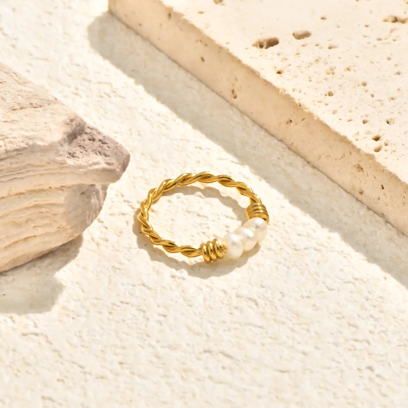 Anillo dorado trenzado con 3 piedras de perla