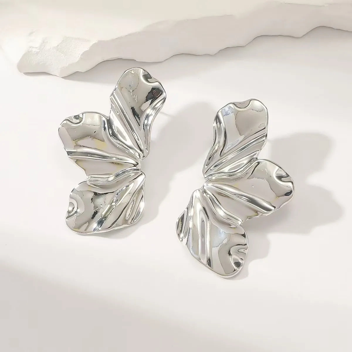 Aretes plateados de media flor con 3 pétalos