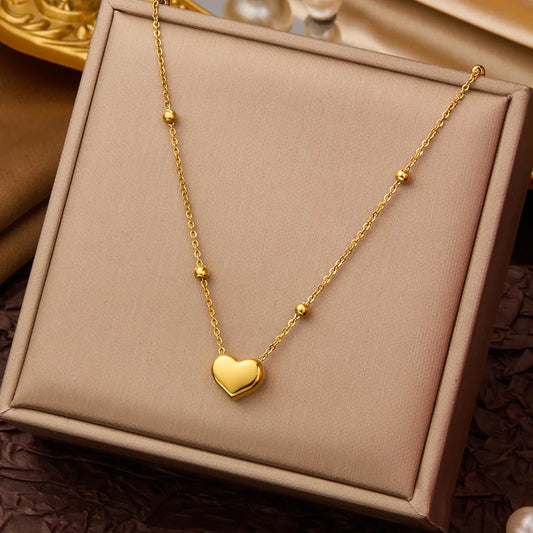 Collar dorado con cuentas redondas y corazón gordo